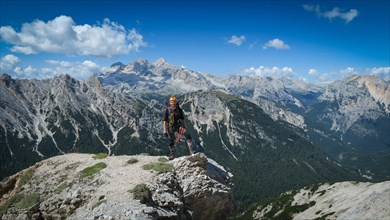 Tourist with equipment on a mountain trail in the Alps. Dolomites