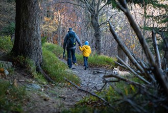 A mother with a child and a dog are walking along the mountain hiking trail. Family spending time. Polish mountains