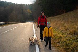 Mom with a child and dogs return from the mountain trail