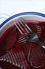 Sliced pickled beetroot with peel and fork