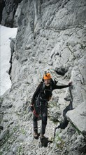 Tourist with equipment on the via ferrata trail in the alps. Zugspitze massif