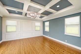 Beautiful blue-gray custom master bedroom complete with entire wainscoting wall