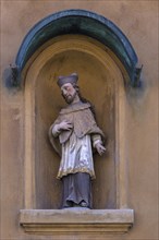Sculpture of St. Nepomuk in a niche on a residential house