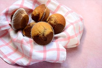 Chocolate muffins in kitchen towel