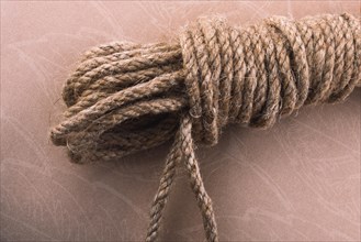 Bundle of linen rope in a sbrown background