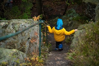 The child descends the stone steps on the hiking trail in the mountains. Polish mountains