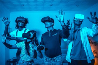 Group of young people in vr glasses in a virtual reality game in a blue light