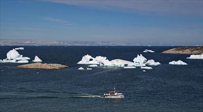 Excursion boat and icebergs in Disko Bay near Ilulissat
