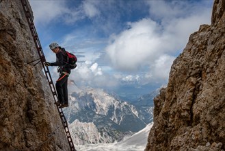 The tutor stands on a rake with a beautiful view in the background of the Alpine Dolomites. Dolomites