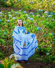 Nicaraguan woman in traditional folk costume in a field of flowers