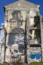 Old building ruin with huge graffiti three heads and skulls