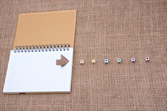 Love cubes and paper arrow on a notebook on canvas