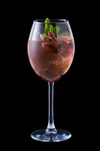 Cold red sangria with dry rosebuds in a wine glass isolated on black background
