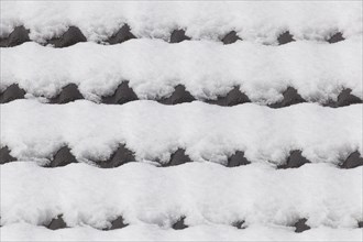 Snowy roof tiles on a roof in winter