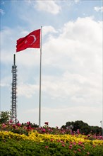 Turkish national flag hang on a pole in a park by the TV tower