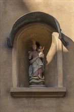 Sculpture of Maria immaculata with the infant Jesus in a niche on a residential house