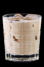 Cocktail white russian in facetted glass on black background