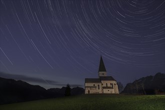 Church on a mountain with star trails in Pongau