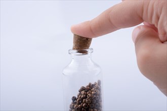 Little perfume glass bottle in hand on a white background