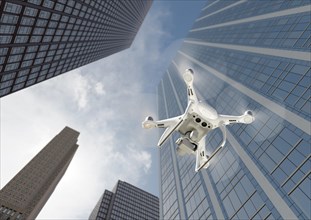 Unmanned aircraft system quadcopter drone in the air among the city and corporate buildings