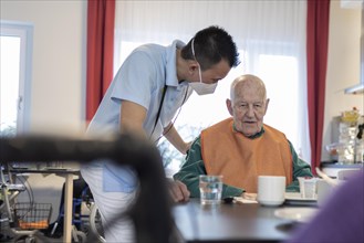 Carer talking to a man in a nursing home