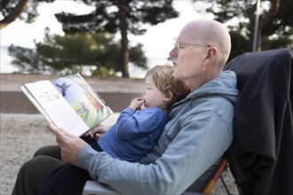 Theme: Grandfather and grandchild reading a book.