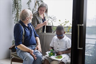 Temporary grandparents. Grandfather volunteers to look after a boy from Africa for a few hours a week.