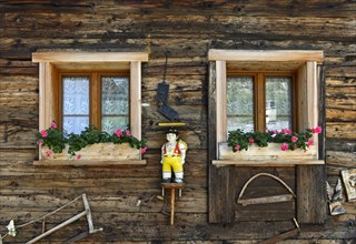 Wooden figure in Appenzell alpine dairymans traditional costume on a chalet