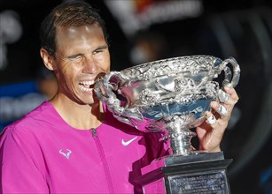 Spanish tennis player Rafael Nadal posing with the championship trophy after winning the mens singles final match of the Australian Open 2022
