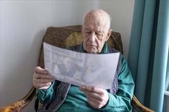 Old man with a photo of himself