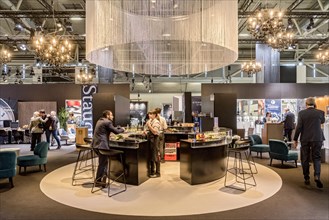 Bar counter with visitors in trade fair stand for high-quality watches