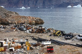 Rubbish at garbage dump and icebergs at the fishing village Uummannaq