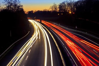 Light traces of moving cars on the A 52 motorway in the evening