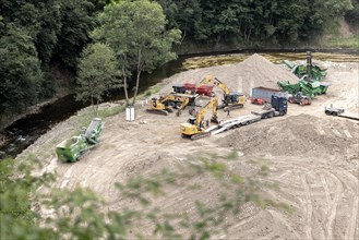 Construction vehicles standing on the riverbed of the Ahr near Schuld