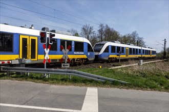 NordWestBahn passes through a level crossing with barriers