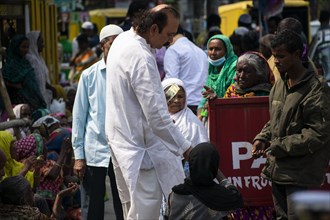 Indian Muslims person give money to needy people after perform the second Friday prayer in the holy month of Ramadan at a Mosque in Guwahati