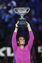 Spanish tennis player Rafael Nadal lifting the championship trophy after winning the mens singles final match of the Australian Open 2022