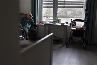 Old man sitting sad and alone in nursing home