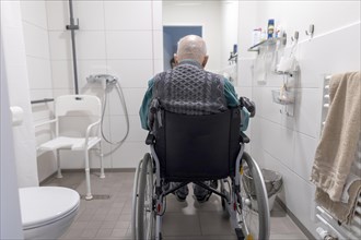 Old man alone in a disabled bathroom