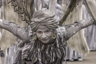 Young smiling woman with wings in grey