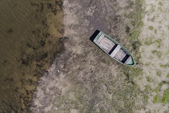 A boat lies on a dry bank at low water level