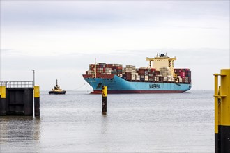 Tugboat guides the container ship Maersk Luz to the unloading berth at Ueberseehafen