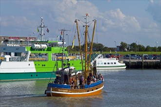 A fishing boat with guests on board enters the harbour of Neuharlingersiel