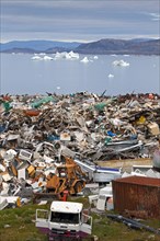 Rubbish at garbage dump and icebergs at Ilulissat