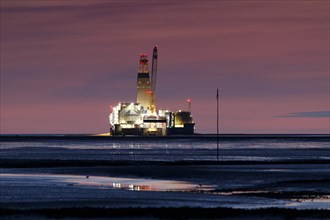 View of Germanys only drilling platform Mittelplate at night and low tide from the Trischendamm