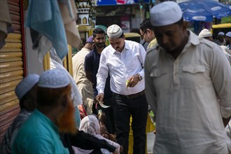 Indian Muslims person give money to needy people after perform the second Friday prayer in the holy month of Ramadan at a Mosque in Guwahati