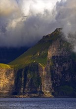 The Faroe Island of Kalsoy in the Atlantic Ocean with Sun and Clouds