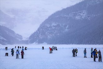 Ice skaters on the frozen mountain lake Lake Louise near Castle Hotel Chateau Lake Louise
