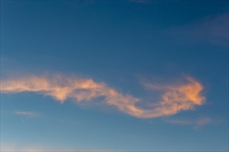 Clouds and blue sky at dawn. Cloud formation is lit by the brilliant pinkish colour of the sunlight. Blue sky in the background with copyspace. Aargau