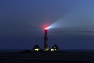 Bright beam of light emitted at night from lantern of the lighthouse Westerhever
